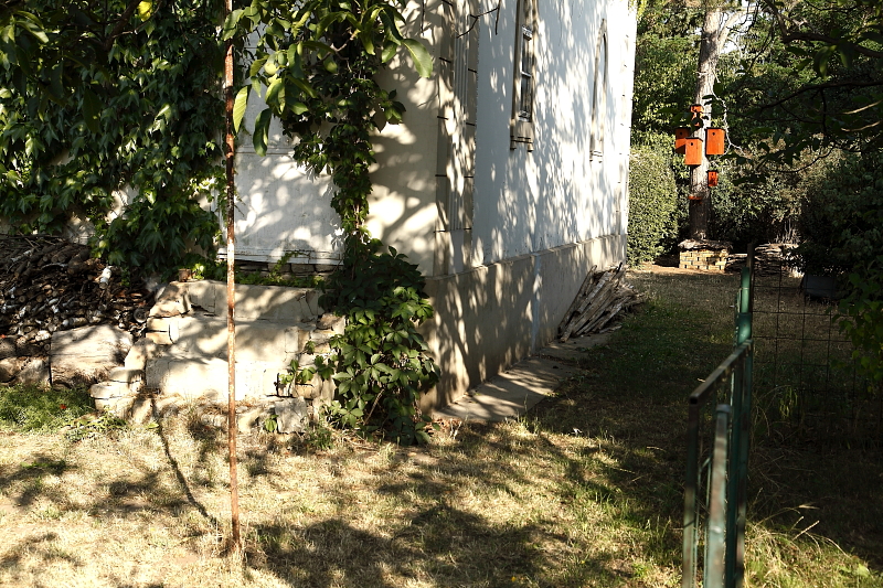 Ebben a kertben az egyik potenciális ökológiai folyosó az épületnek ezen a részén, az alapot övező járda jelenti. Ez képez összeköttetést a bal oldali természetvédelmi farakás, és a kép jobb oldali hátterében látható „ökörszemkastély” és egérvár között (Fotó: Orbán Zoltán).